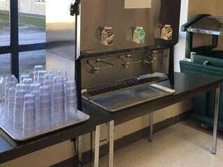 A bulk milk dispenser in a school cafeteria