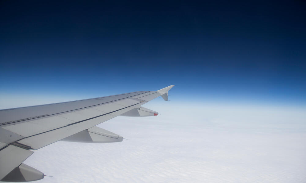 Airplane wing against the background of clouds and sky