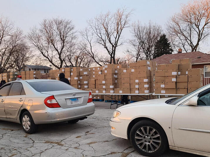 cars lined up in front of tables full of boxes