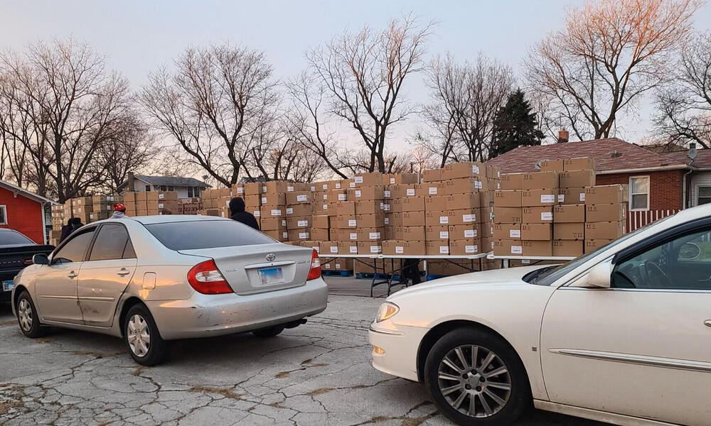 cars lined up in front of tables full of boxes