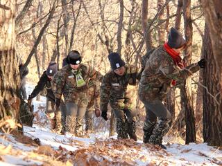 An all-female team of rangers walks through a snowy forest in China looking for signs of tigers