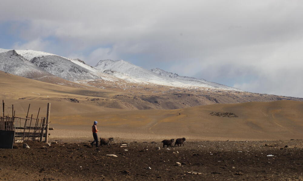 A landscape image with a man in the mountains of Kyrgyzstan