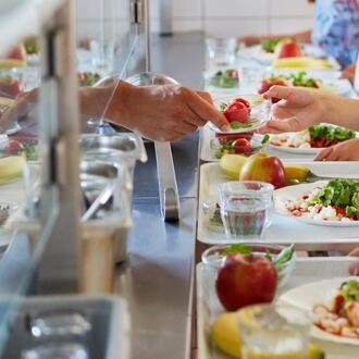 Students being served lunch in line at a school cafeteria
