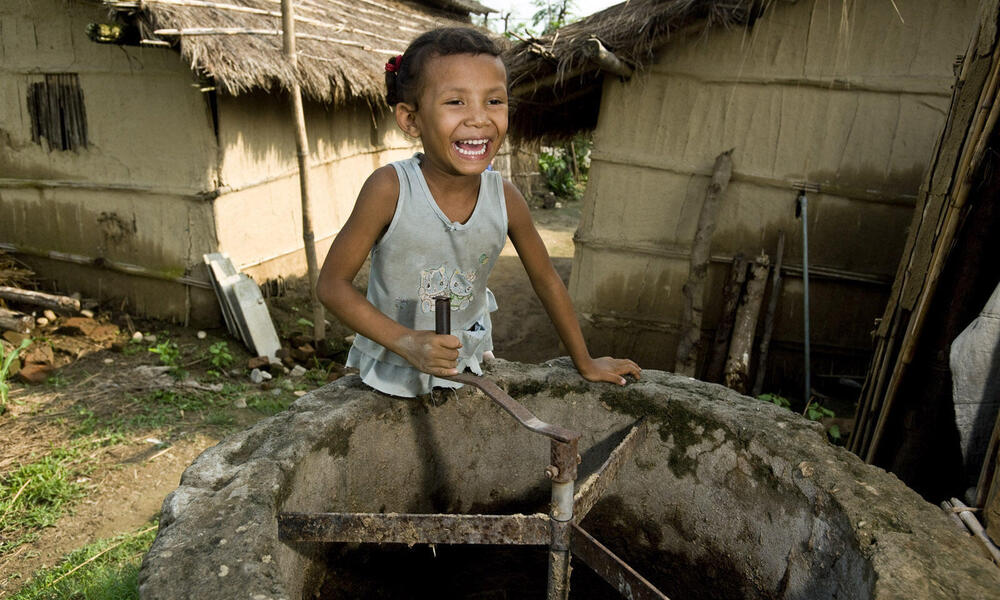 Surkhha Darai, age 5, turns the manure stirrer at her family home in the Bio-Gas Village.