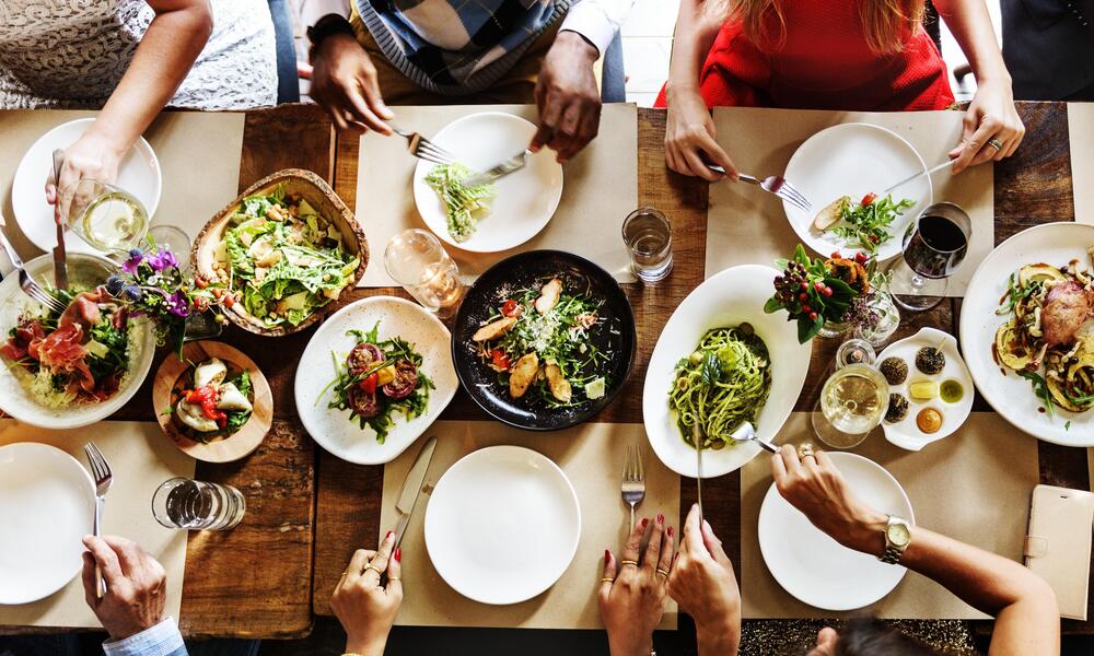 aerial shot of a group of people sitting around a table sharing a meal