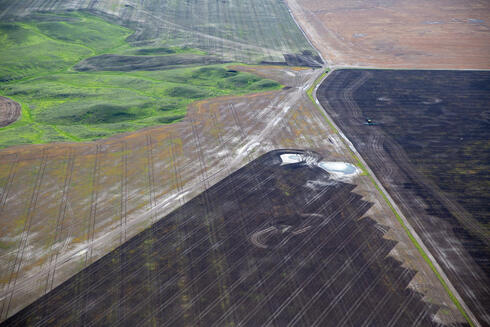 A patchwork of plowed brown land next to some remaining intact green grasslands