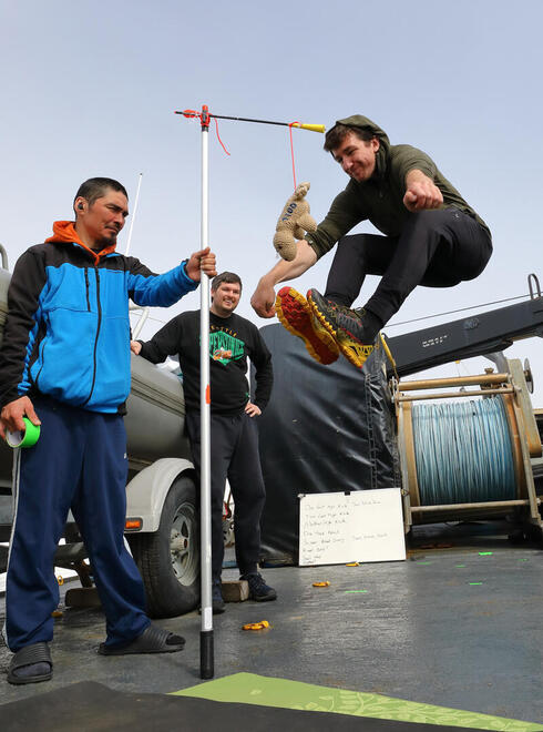 A man jumps high to touch a target with his feet
