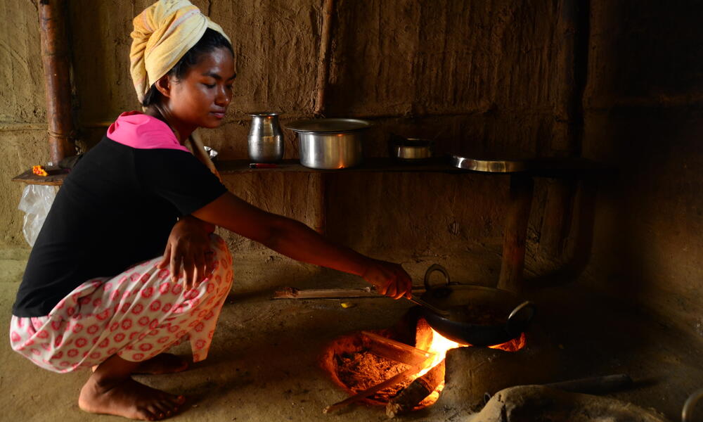 A Nepali woman cooks over her firewood stove. The use of open fires in homes can cause respiratory illness, and contribute to deforestation.