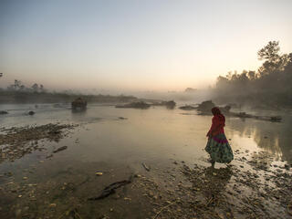 Woman walking through lake in Nepal