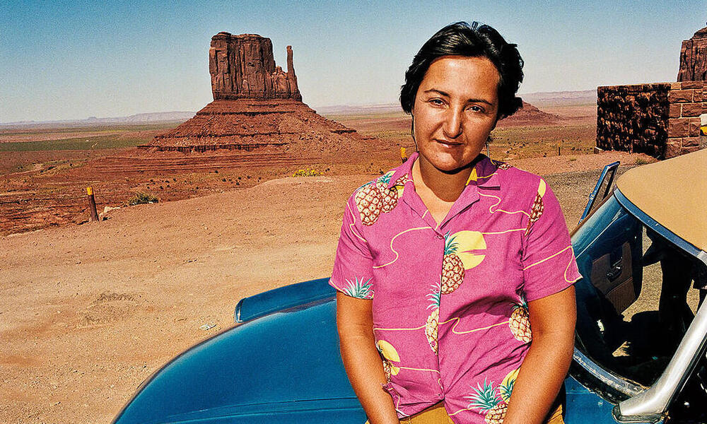 A woman poses in front of The Mittens in Navajo County, Arizona