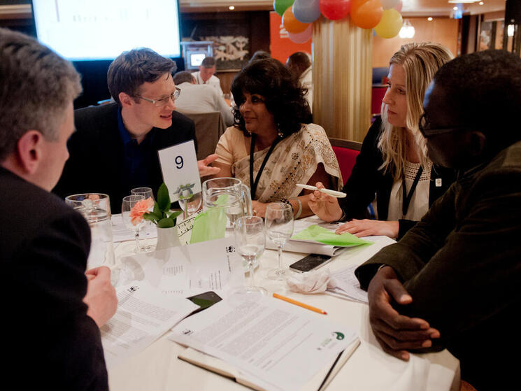 A group of people talk around a table