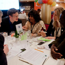 A group of people talk around a table