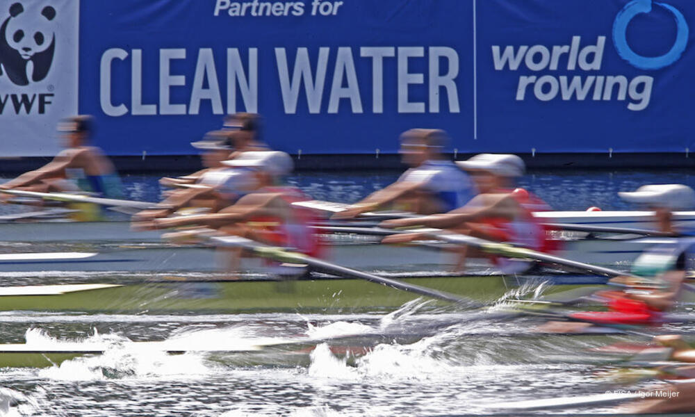 Rowers and partners for clean water sign in the background.